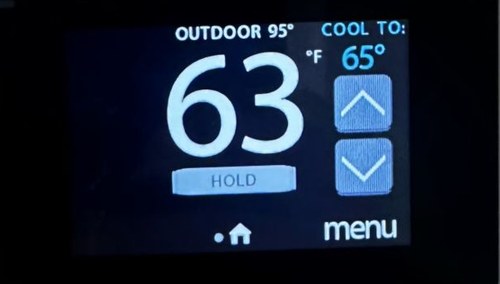 Thermostat showing 63°F indoor with 95°F outdoor temperature