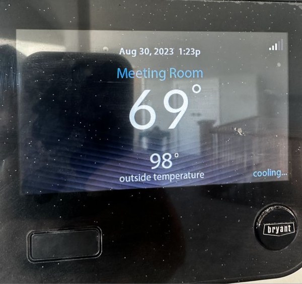 Bryant thermostat showing 69°F in meeting room with 98°F outdoor